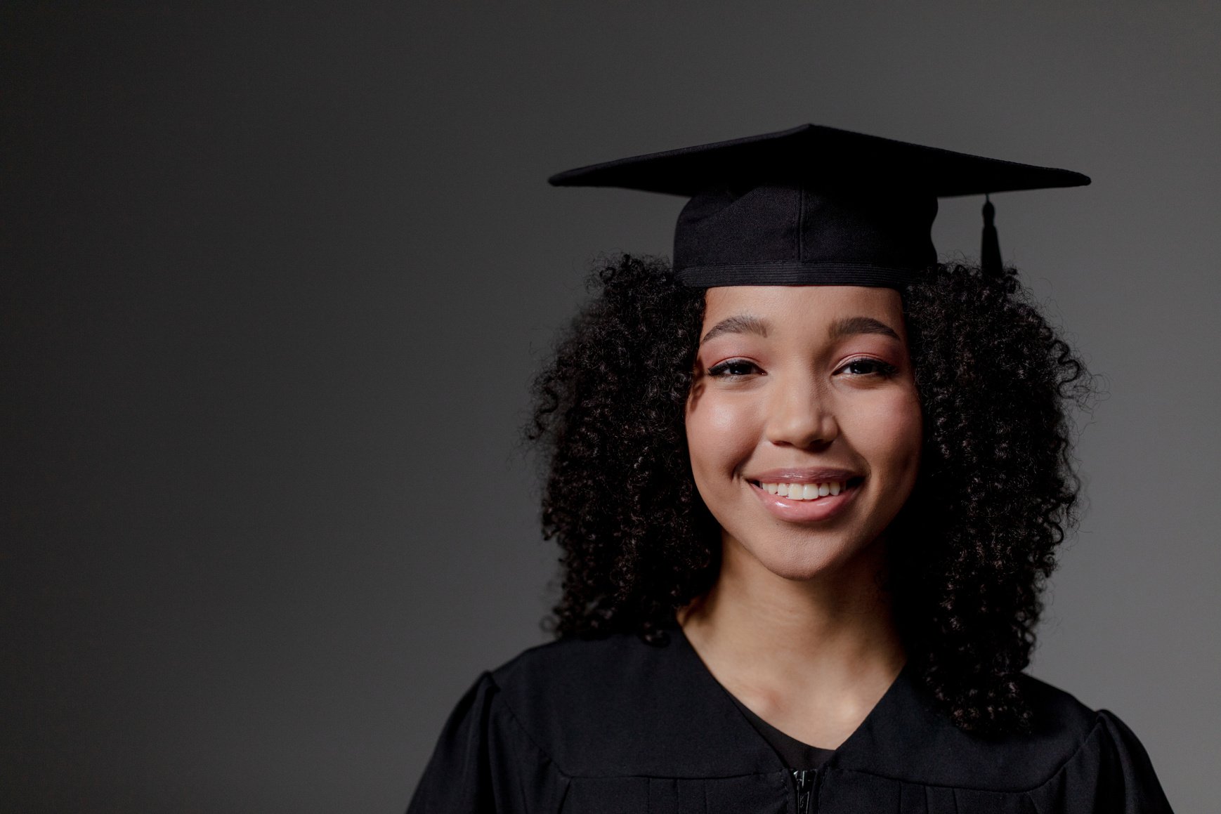 A black female student looking at camera and wearing Square academic cap